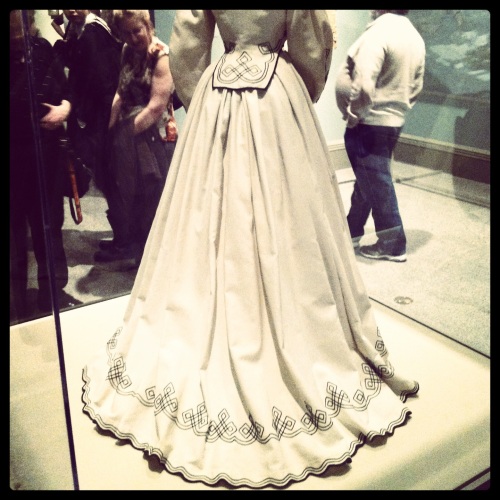 1860s cream cotton pique dress with black scrollwork.